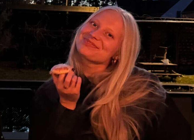 Je ziet me hier pizza eten op een bankje.